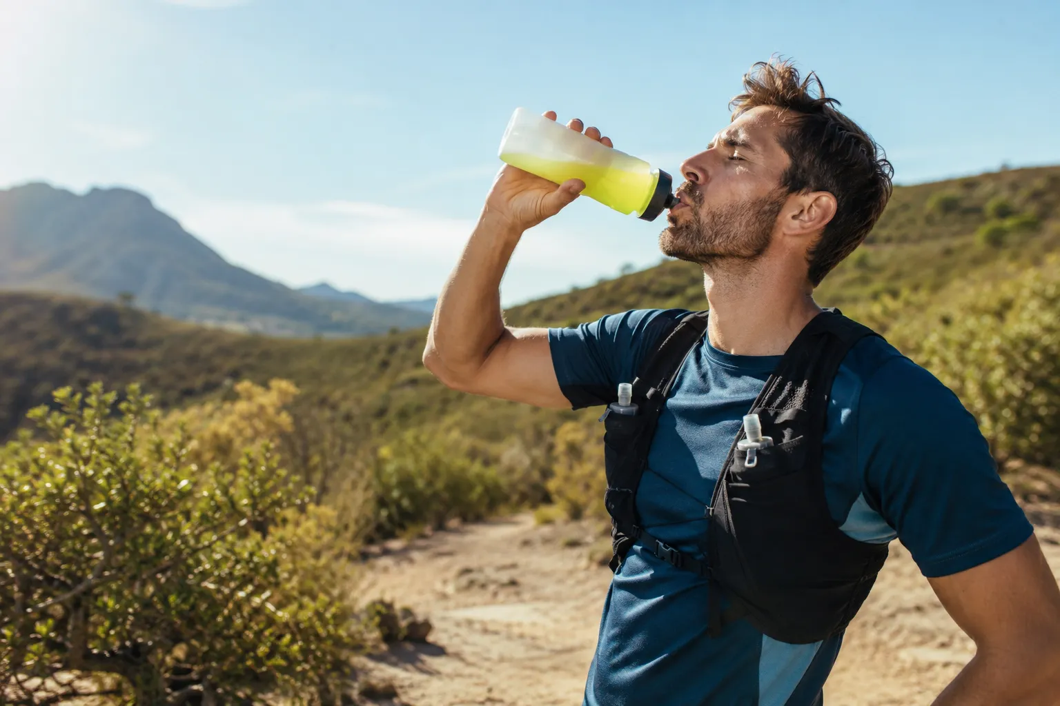 Coureur s'hydratant avec une boisson aux électrolytes pendant l'effort