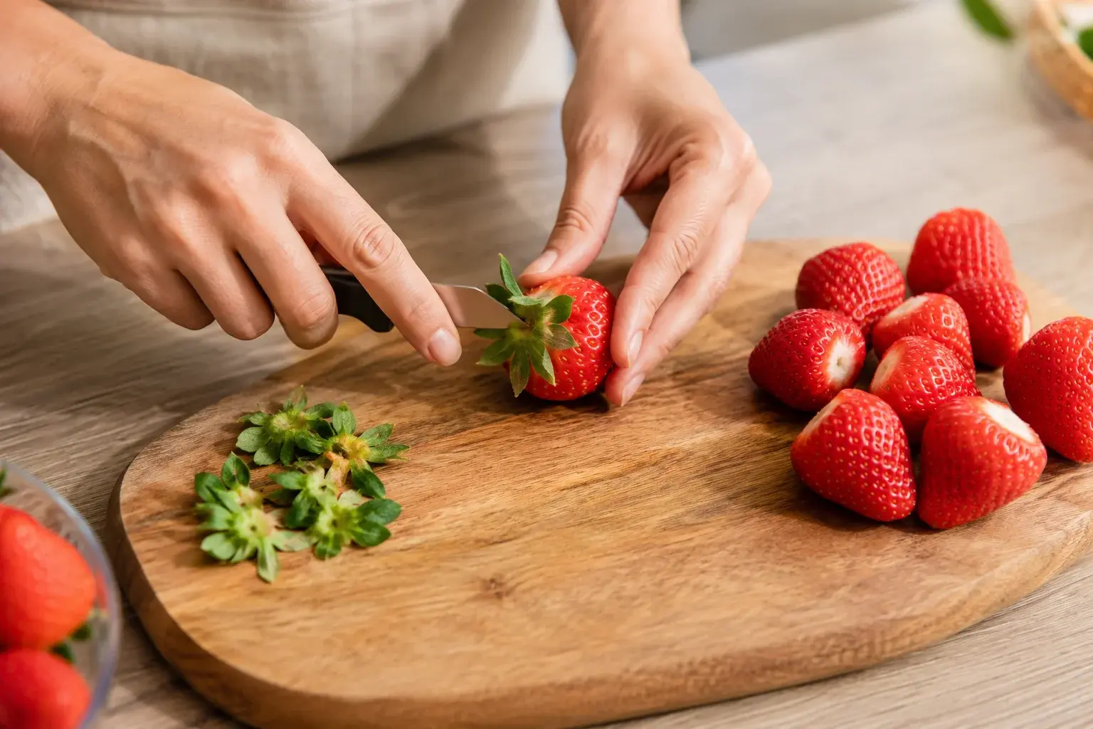 Fraises fraîches équeutées sur une planche à découper prêtes pour le smoothie