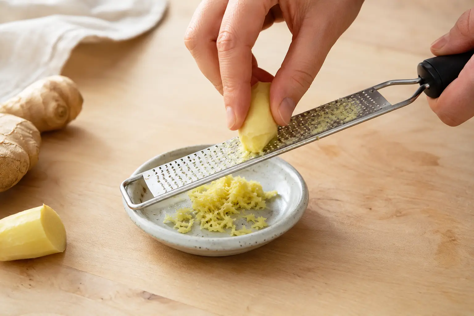 Gingembre frais râpé sur une microplane pour la boisson pré-workout