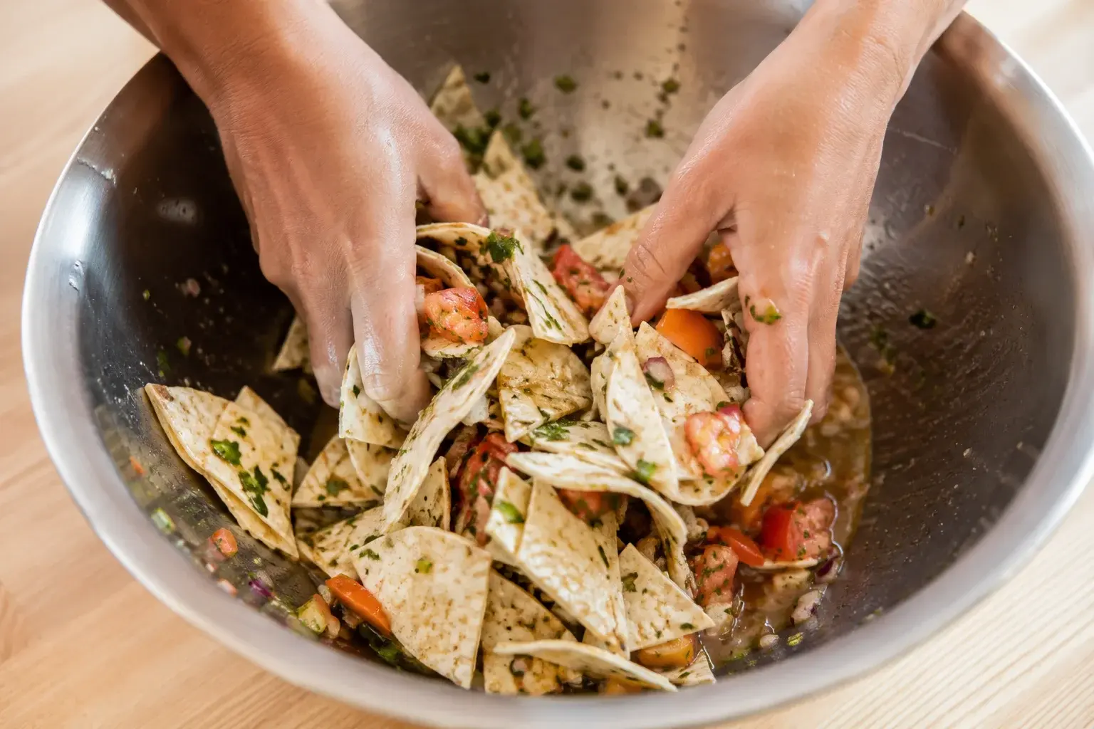 Morceaux de wraps protéinés mélangés avec l'assaisonnement sel-vinaigre dans un saladier