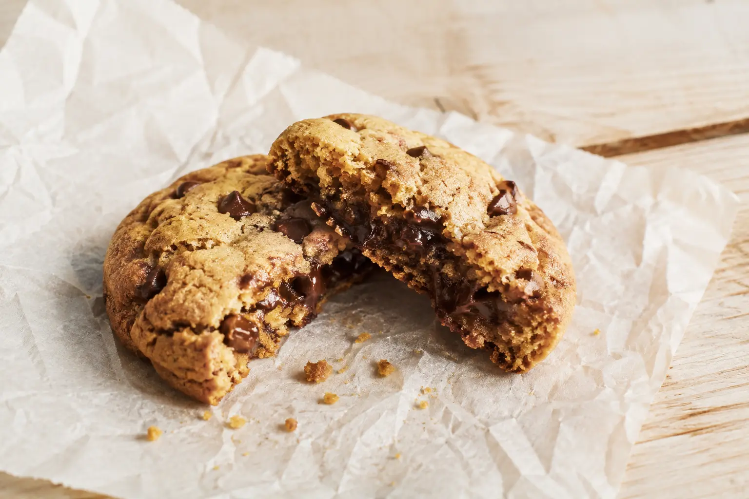 Gros plan sur un cookie au beurre de cacahuète protéiné coupé en deux montrant sa texture fondante