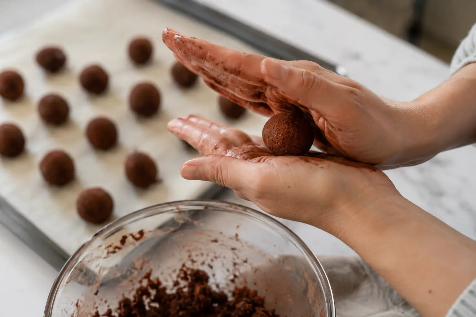 Mains roulant une boule de pâte à truffes café-chocolat