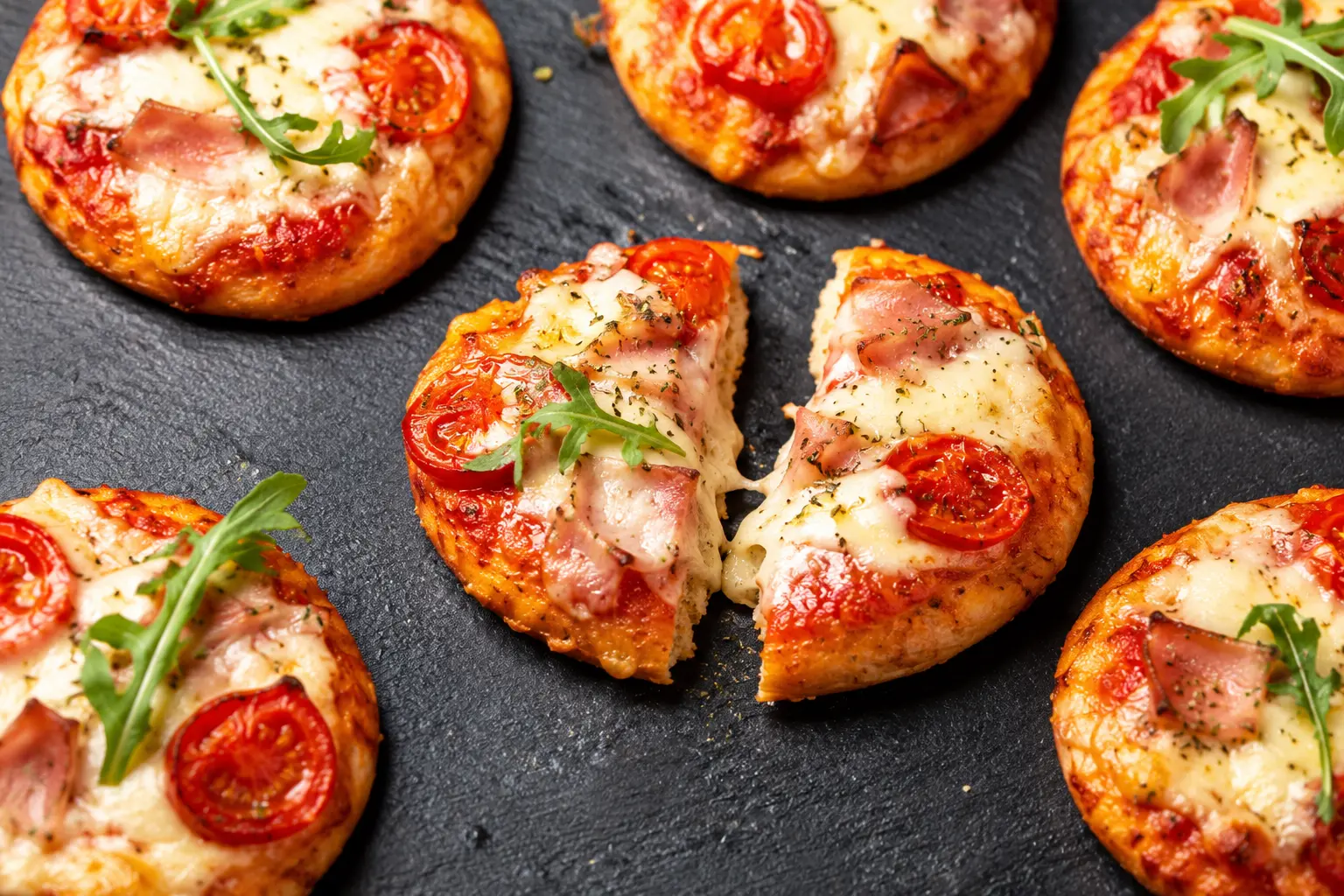 Gros plan sur une mini-pizza protéinée garnie de dinde fumée et mozzarella fondue
