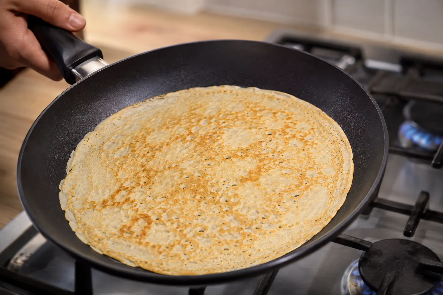 Crêpe protéinée en train de cuire dans une poêle antiadhésive