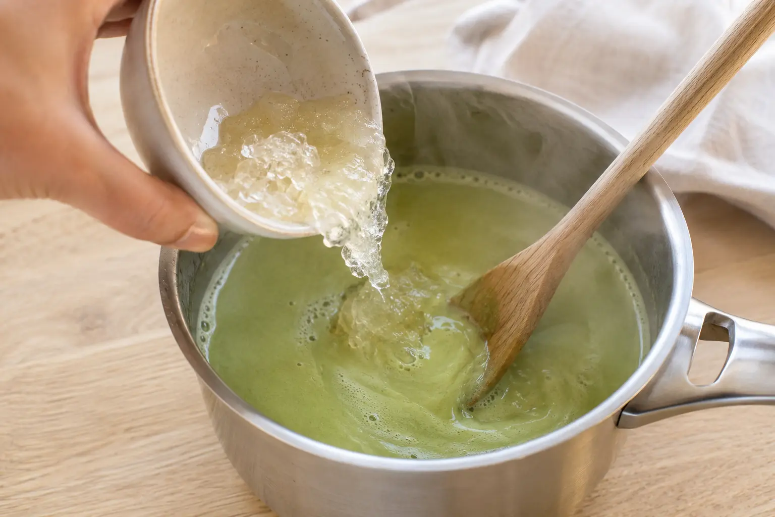 Gélatine ajoutée dans le lait au matcha chaud, mélangée à la cuillère