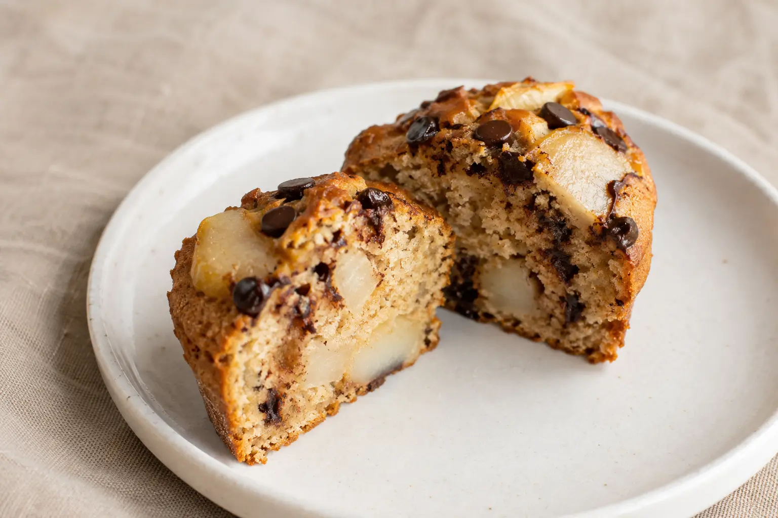 Muffin poire-chocolat protéiné coupé en deux montrant la texture moelleuse et les pépites de chocolat fondues