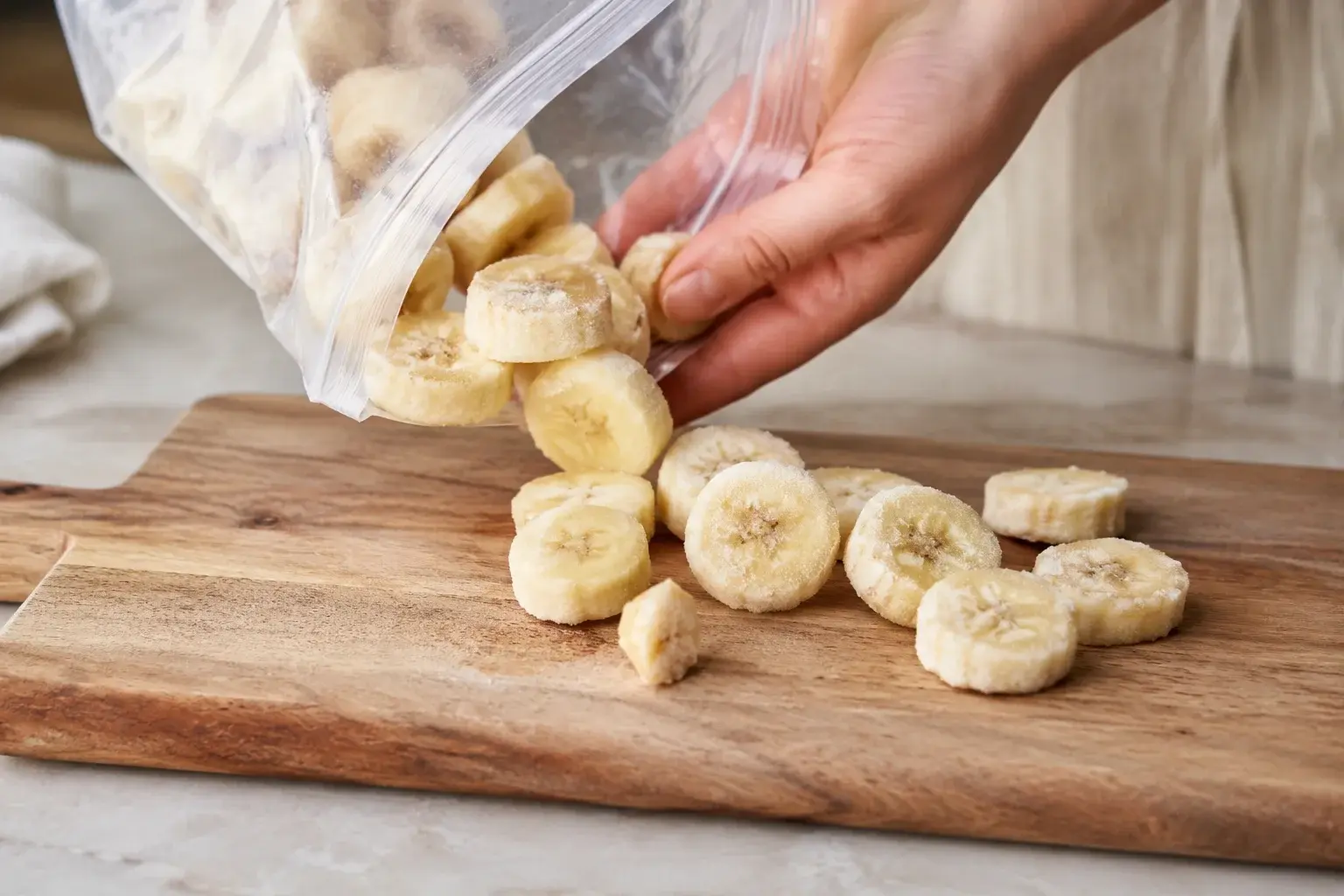 Rondelles de banane congelées sorties du congélateur sur une planche