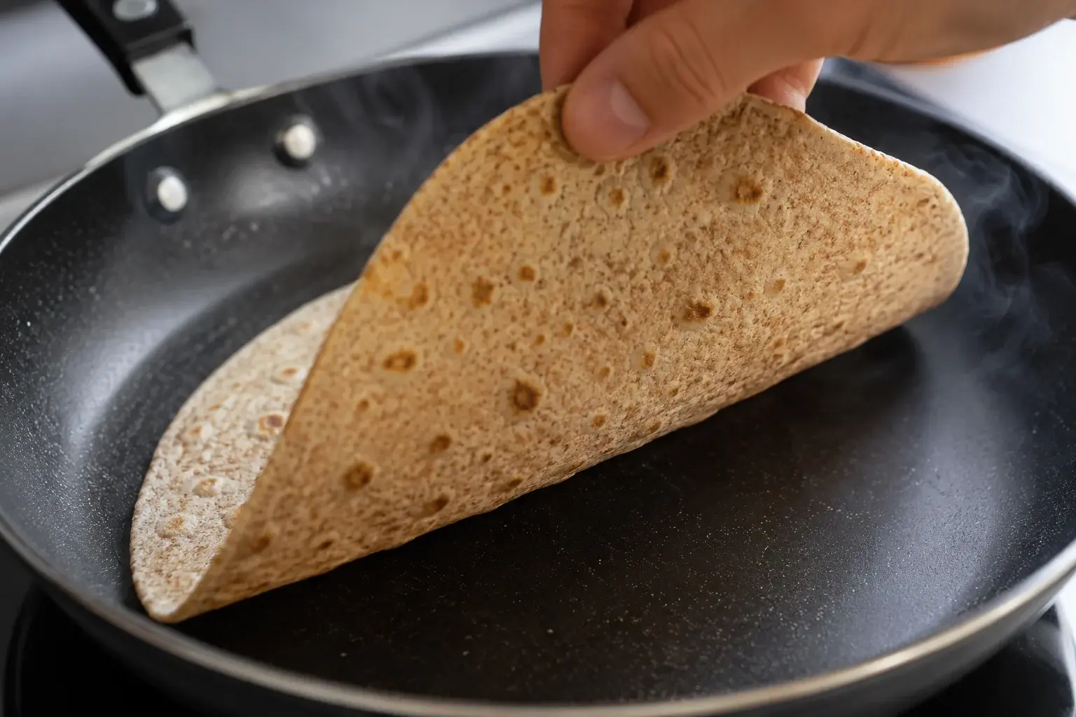 Tortilla de blé complet chauffée dans une poêle sèche