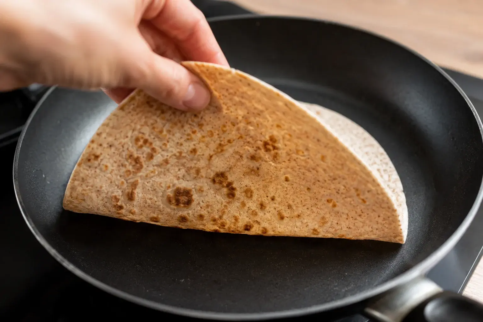 Tortilla de blé complet chauffée dans une poêle sèche