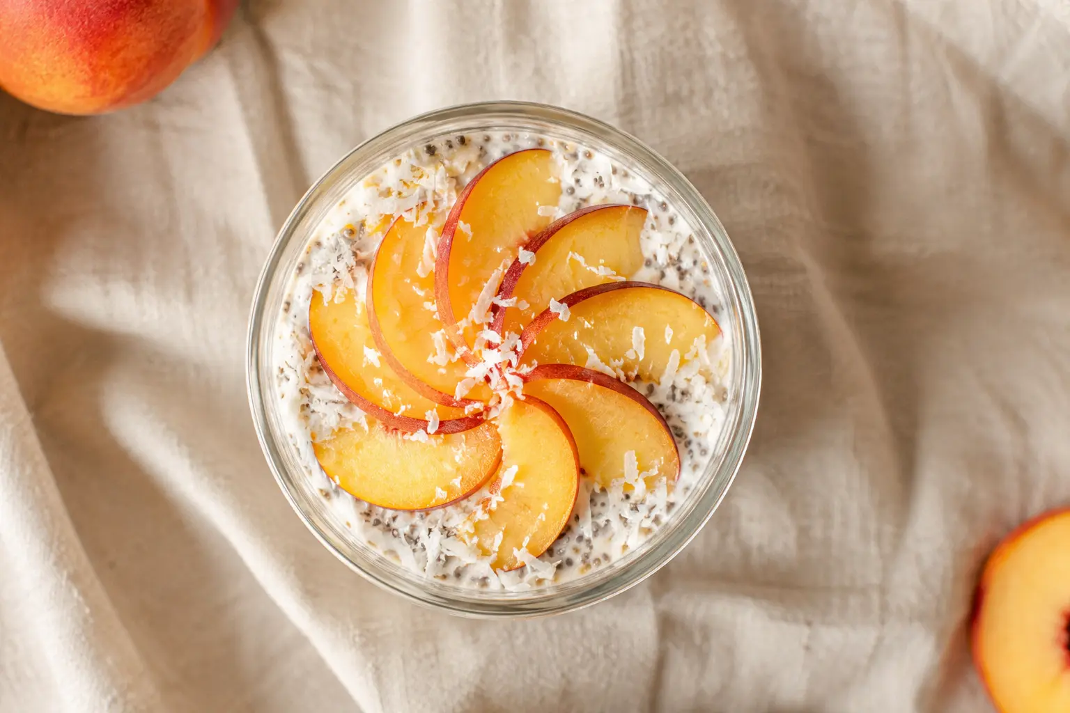 Overnight oats pêche-coco vus de dessus avec garniture de pêche fraîche et copeaux de coco