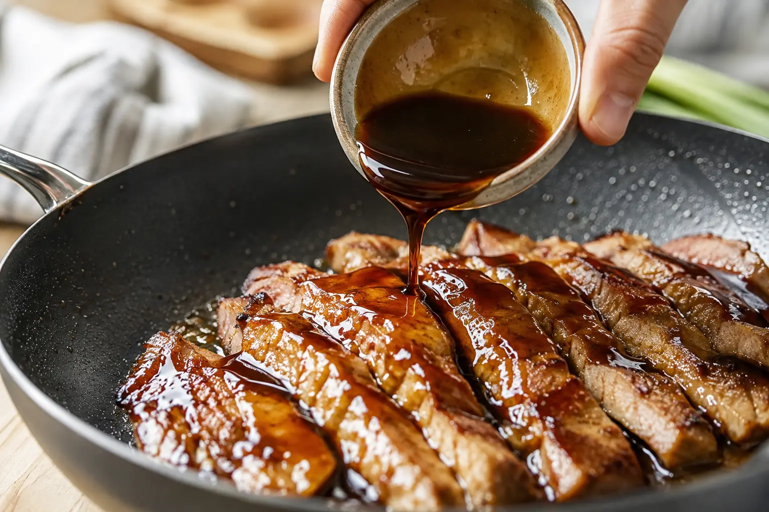 Sauce teriyaki en train de caraméliser sur les tranches de porc dans la poêle
