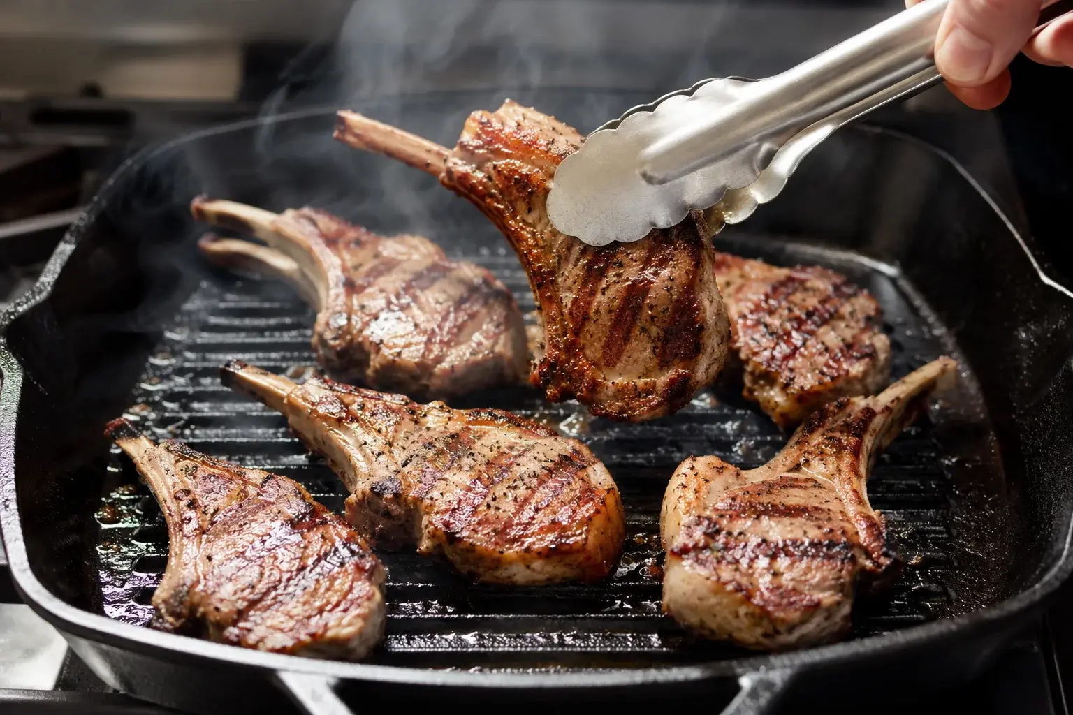 Côtelettes d'agneau en train de griller sur une poêle-gril avec de la fumée