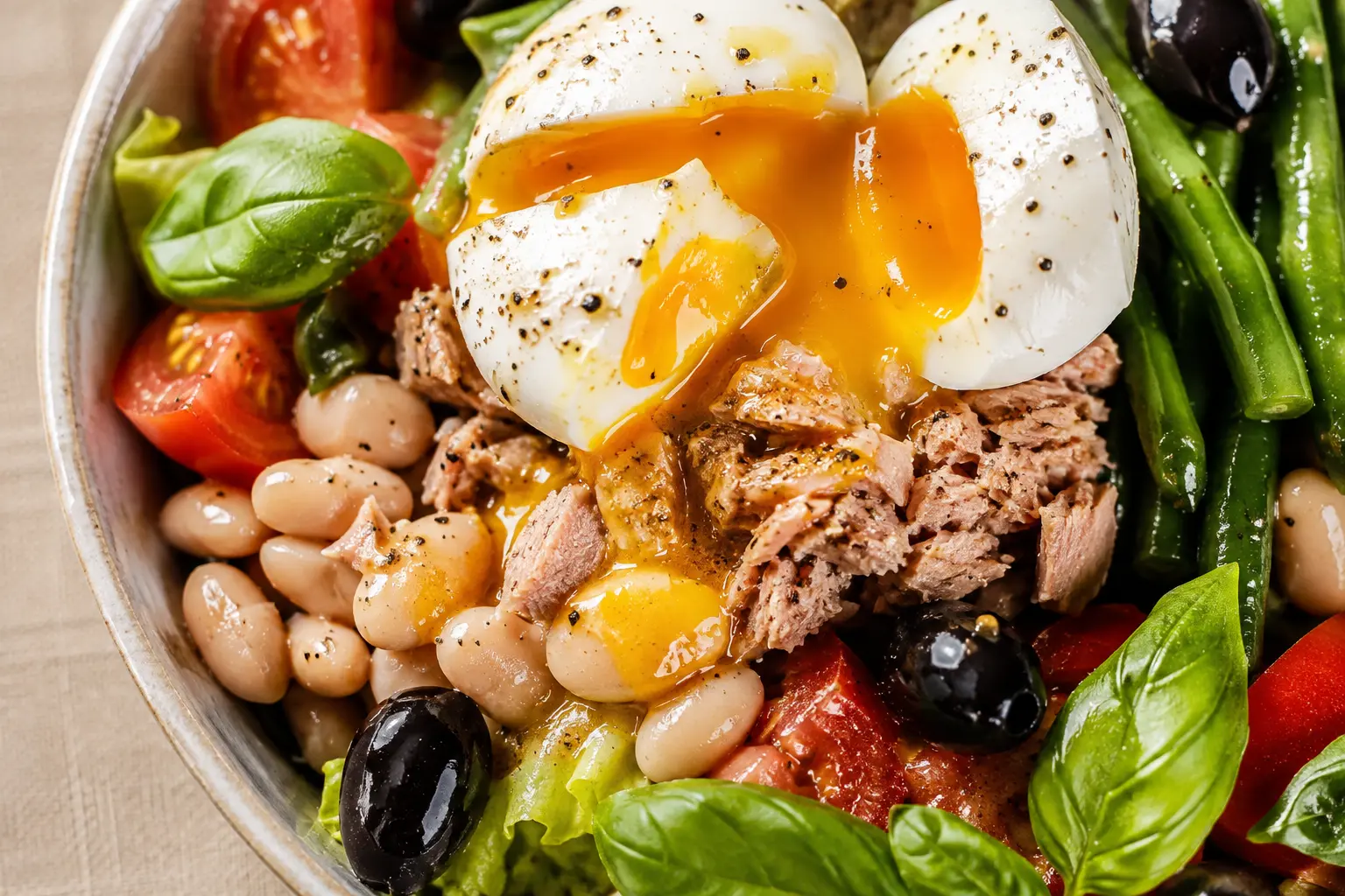 Vue rapprochée de la salade niçoise protéinée montrant le détail des œufs mollets et du thon